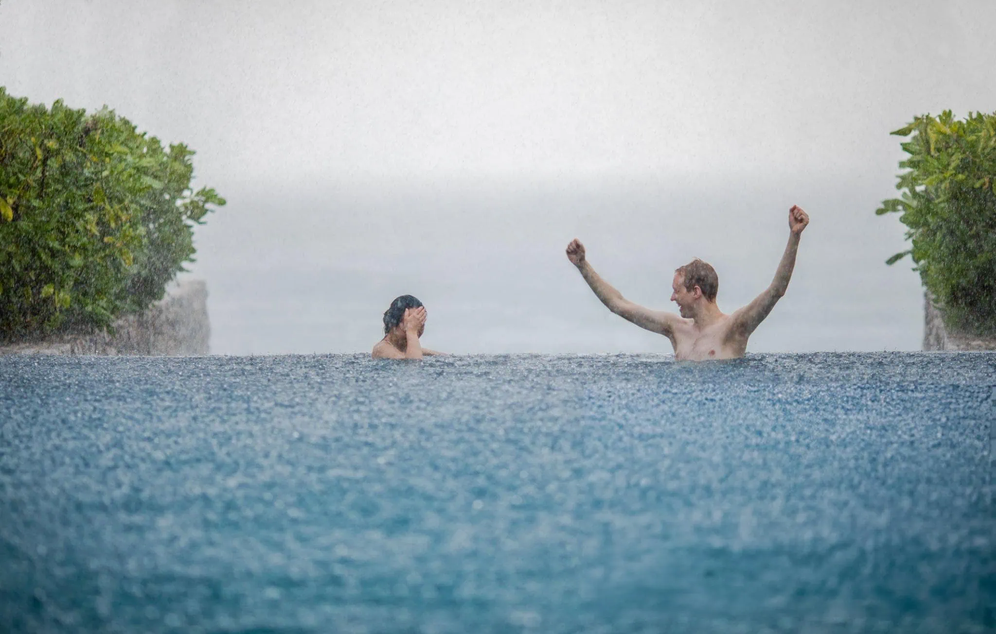 swimming in an infinity pool under light rain